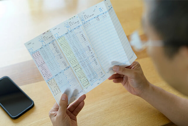 健康診断結果表を確認する男性のイメージ