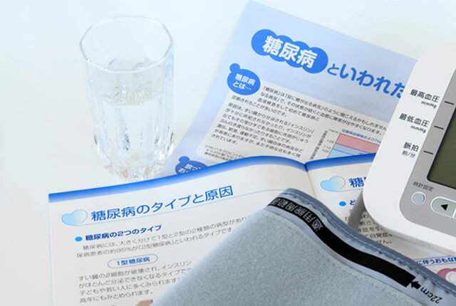 糖尿病の資料と血圧計のイメージ