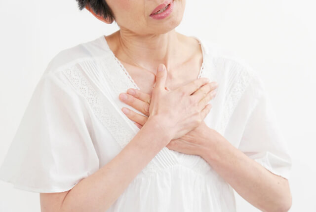両手で胸をおさえる女性