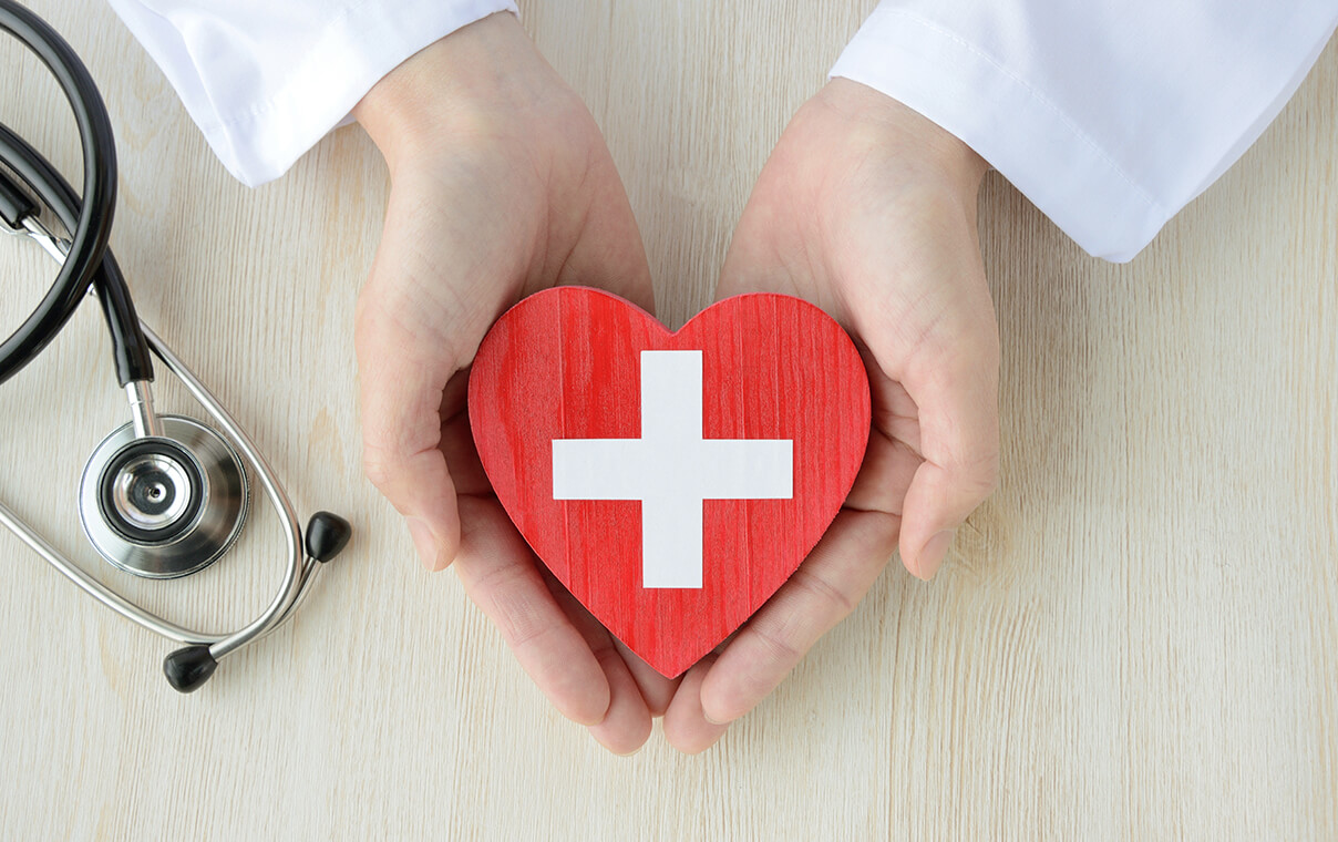 ハートの模型を両手で包み込む医師のイメージ